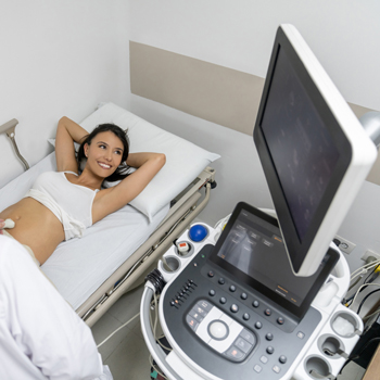woman laying in doctor's bed while ultrasound is used on her uterus